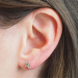 Close-up of an ear with a leaf silver earring