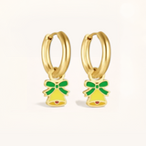 Gold hoop earrings with green and yellow bell charms on a light pink background