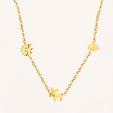 Gold necklace with Christmas charms on a light background.