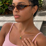 Woman wearing the Gold Classic Cushion Stone Necklace with an emerald gemstone.