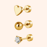 Gold heart-shaped, round, and diamond stud earrings on a pink background