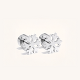 Silver snowflake-shaped earrings on a light background