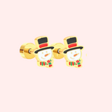 Pair of gold snowman earrings on a light pink background.