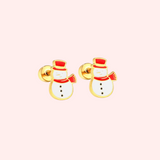 Pair of gold snowman-shaped earrings on a light pink background.