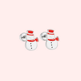 Pair of silver snowman-shaped earrings on a light pink background.
