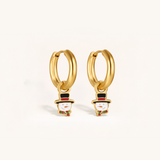 Gold hoop earrings with snowman charms on a light background.