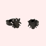 A pair of black hypoallergenic stainless steel earrings designed to resemble a spider.