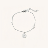 Silver bracelet with a star charm on a white background