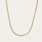 Gold chain necklace on a light beige background