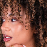 Close-up of a woman with curly hair wearing earrings
