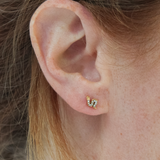 Close-up of a girl wearing a gold serpent snake earring.
