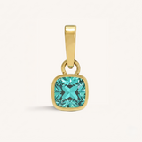 Gold pendant with a turquoise gemstone on a white background.