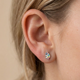 A girl wearing a pair of rainbow unicorn flat back earrings.