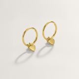 Mini heart huggie hypoallergenic hoop earrings in gold on white background.