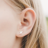 Girl wearing mini lightning hypoallergenic flat back earrings in silver
