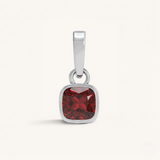 Silver pendant with a red garnet gemstone on a white background.