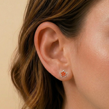 A girl wearing a pair of orange starfish flat back earrings.