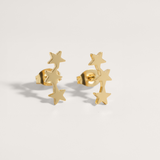 Gold star-shaped earrings on a light gray background.