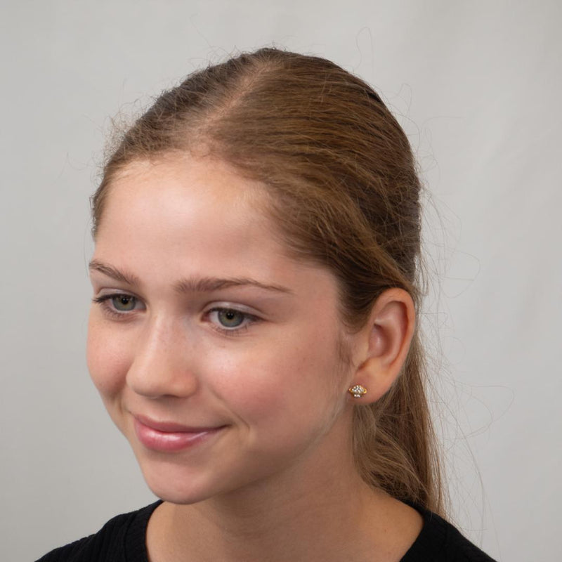 Girl wearing gold planet flat back earring.