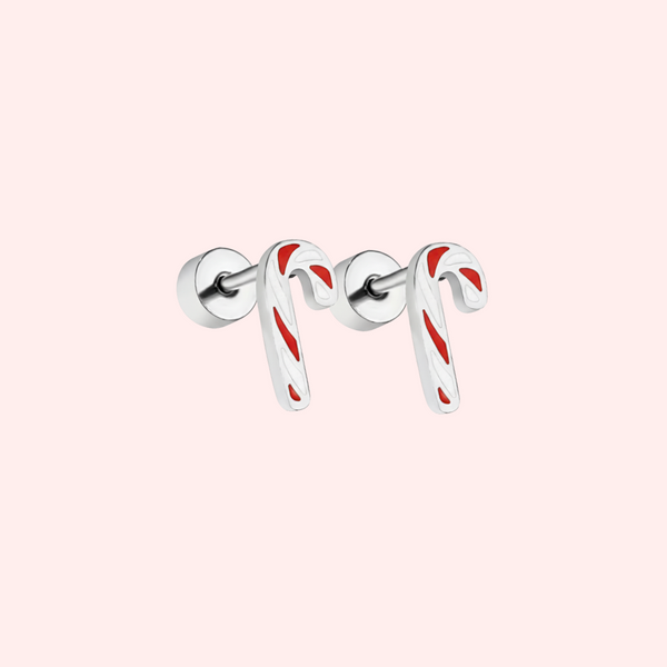 Silver candy cane-shaped earrings with red stripes on a light pink background
