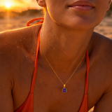 Woman wearing the Gold Classic Cushion Stone Necklace with an amethyst gemstone.