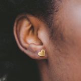 Close-up of a girl wearing a gold heart-earring.