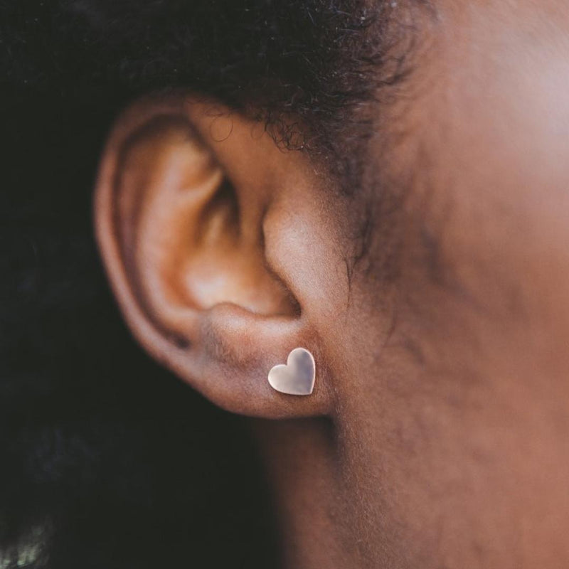 Silver heart-shaped earring worn by a girl.