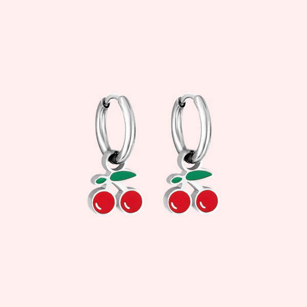 Silver cherry hoop earrings on a light pink background