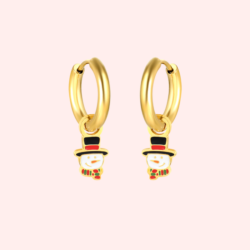 Gold hoop earrings with snowman charms on a light pink background.