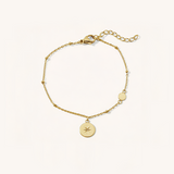 Gold bracelet with star-shaped charm on a white background