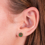 Close-up of a girl wearing a green wreath earring.