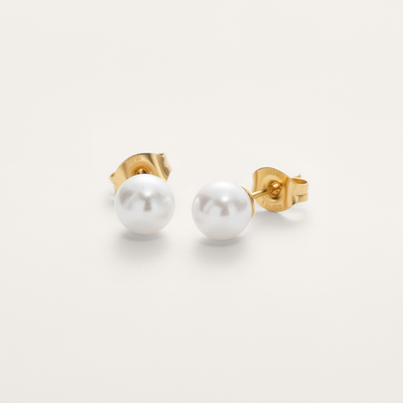 Classic white pearl bead hypoallergenic earrings in gold on white background.