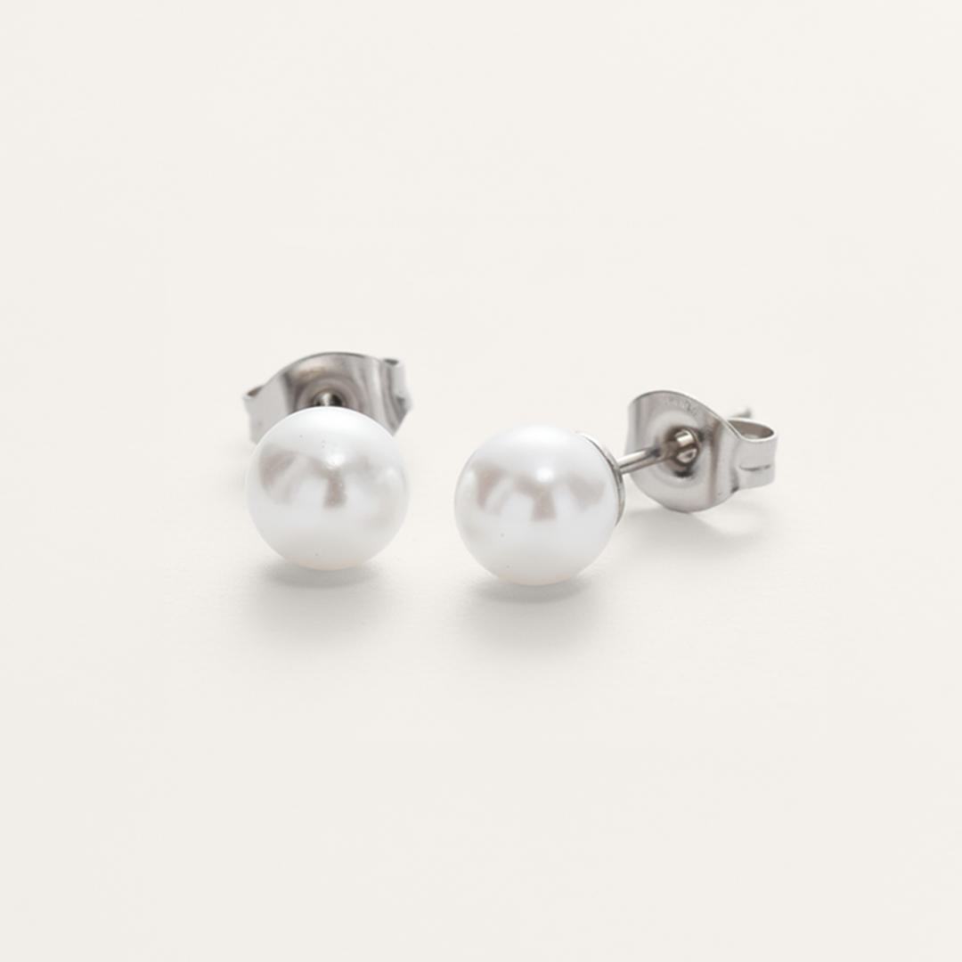 Classic white pearl bead hypoallergenic earrings in silver on white background