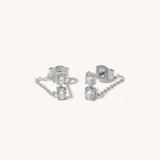 Pair of silver earrings with clear gemstones on a white background