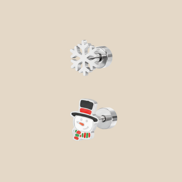 A silver Christmas set with snowflake and snowman earrings on a beige background.