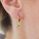 Close-up of a girl wearing a gold mystic web hoop earring.