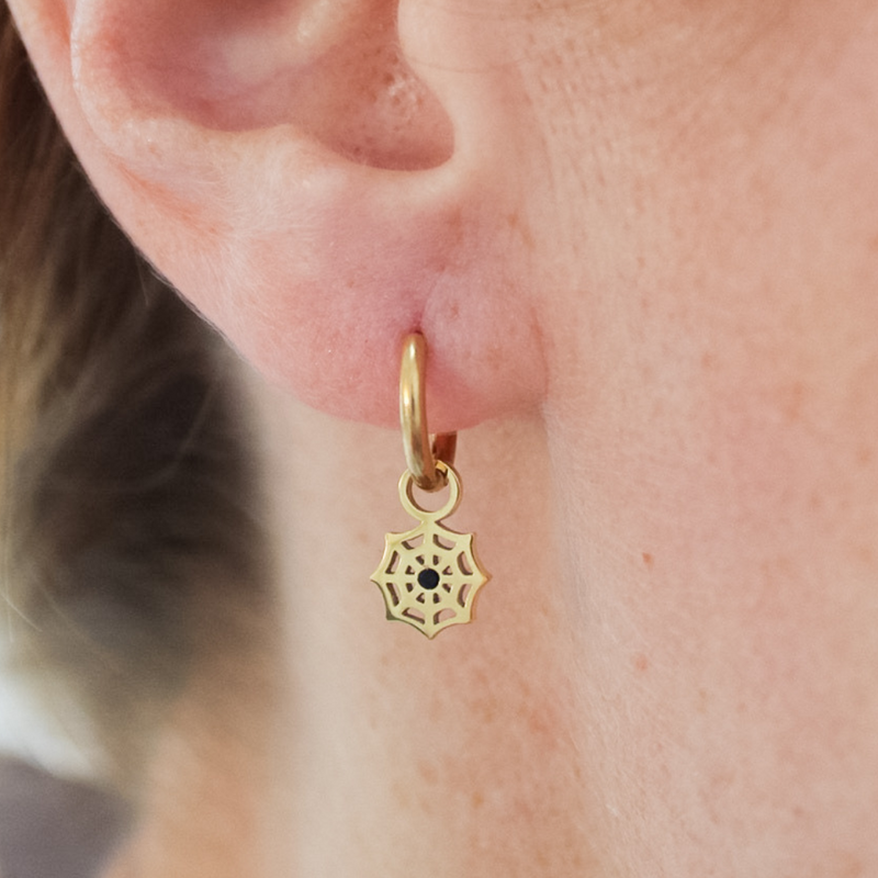 Close-up of a girl wearing a gold mystic web hoop earring.