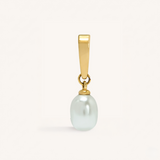 Gold pendant with a white pearl on a light beige background