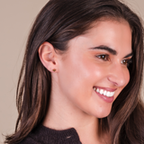Close-up of a girl with a neutral background wearing the gold heart flat backs.