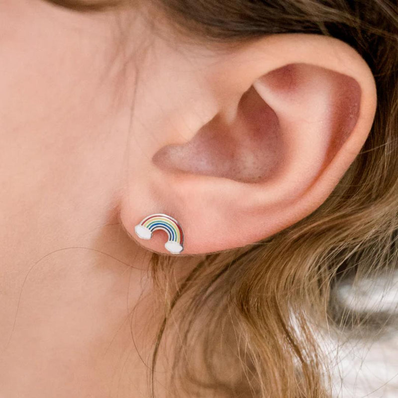 Close-up of a girl wearing a rainbow-shaped earring.