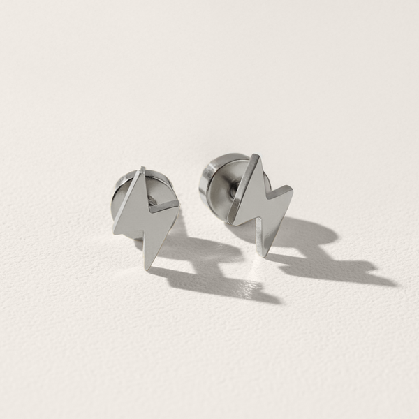 Pair of silver lightning bolt earrings on a light gray background