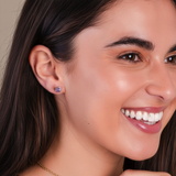 Close-up of a woman wearing a blue earring with a neutral background