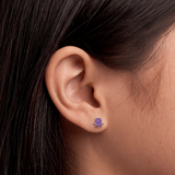A girl wearing a pair of purple octopus flat back earrings.