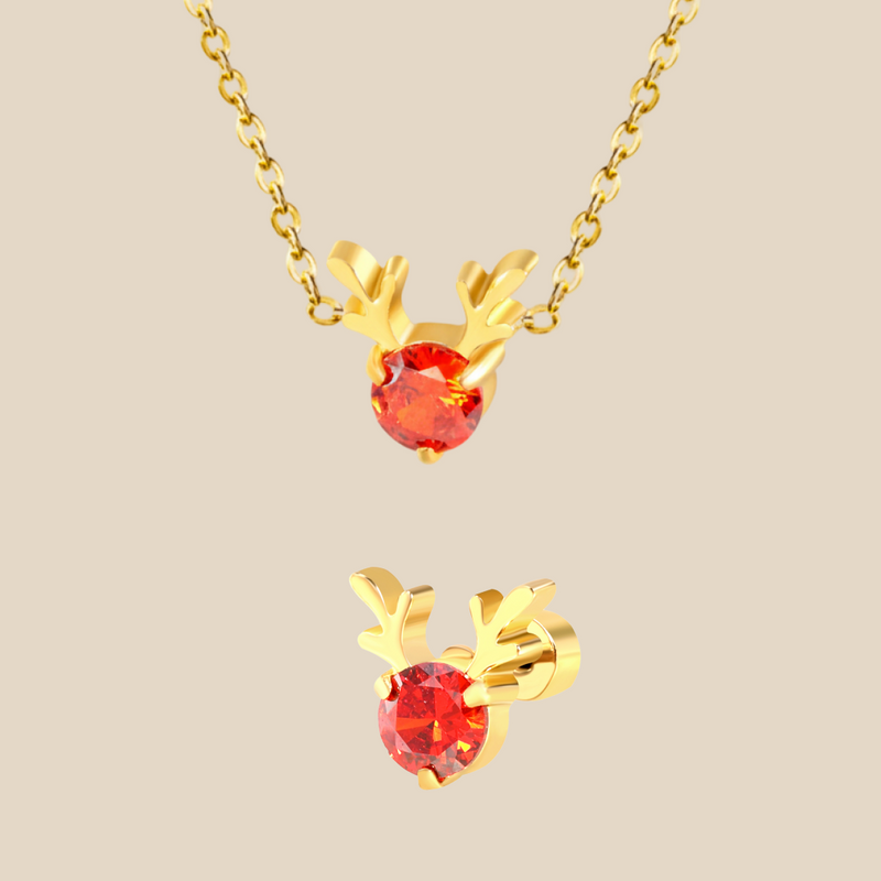 A Christmas set featuring a gold Rudolph charm necklace and earrings on a beige background.
