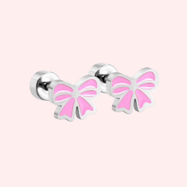 Pair of silver bow-shaped earrings with a pink centre on a light pink background