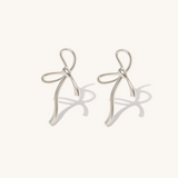 Silver bow-shaped earrings on a white background.