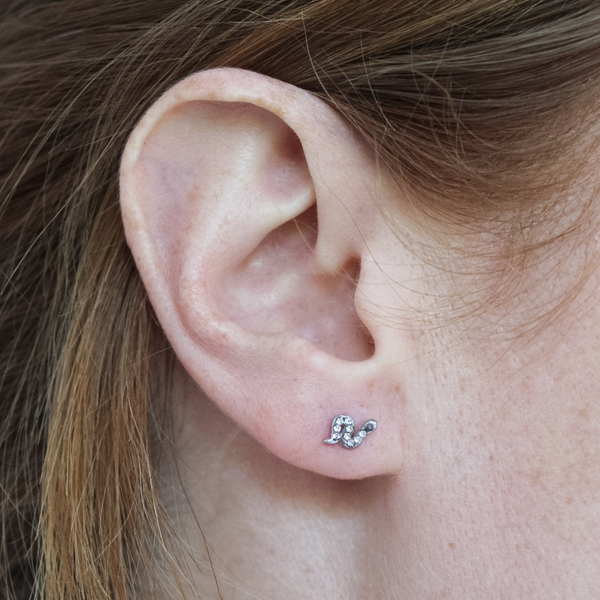 Close-up of a girl wearing a silver serpent snake earring.