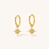 Gold hoop earrings with star designs on a white background