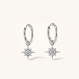 Silver hoop earrings with star-shaped charms on a white background